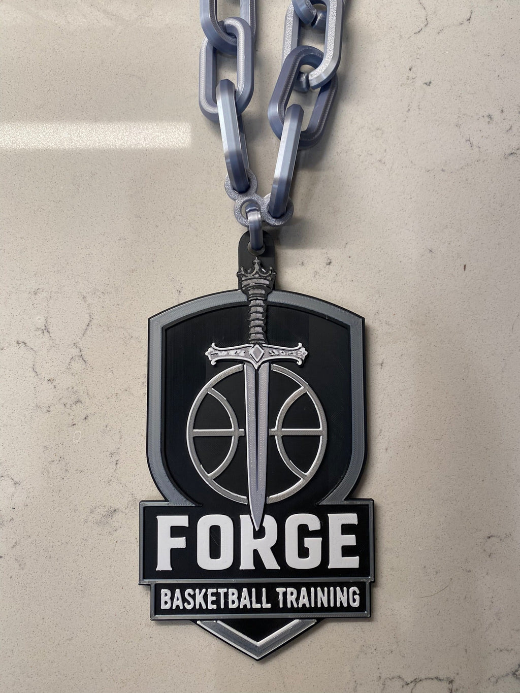 Basketball training logo with chain on a textured surface