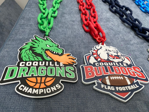 Two sports team Hustle Chains, one for Coquille Dragons and one for Coquille Bulldogs, on a textured surface. Basketball and Football.